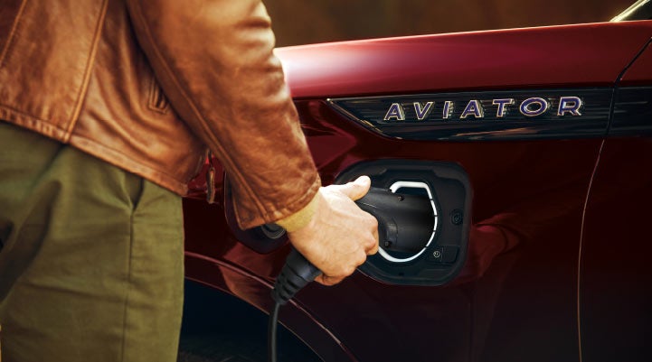 A hand is shown plugging in the charger into the charging port of a 2021 Lincoln Aviator | Baldwin Lincoln in Covington LA