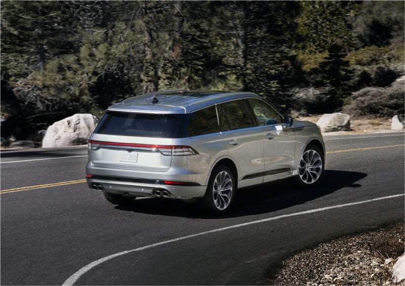 A 2023 Lincoln Aviator® Grand Touring model is shown being driven on a tight turn of a mountain road | Baldwin Lincoln in Covington LA