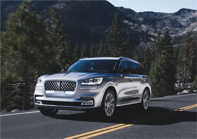 A 2023 Lincoln Aviator® Grand Touring SUV being driven on a winding road to demonstrate the capabilities of all-wheel drive | Baldwin Lincoln in Covington LA
