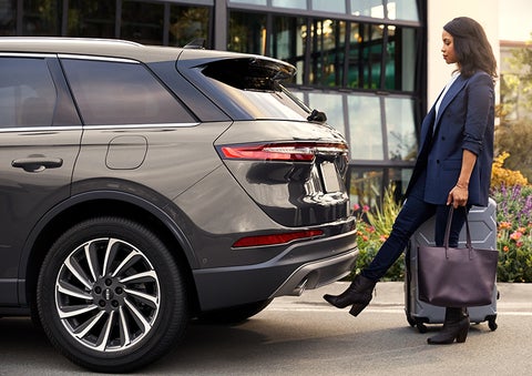 A woman with her hands full uses her foot to activate the available hands-free liftgate. | Baldwin Lincoln in Covington LA