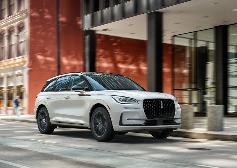 The 2024 Lincoln Corsair® SUV with the Jet Appearance Package and a Pristine White exterior is parked on a city street. | Baldwin Lincoln in Covington LA